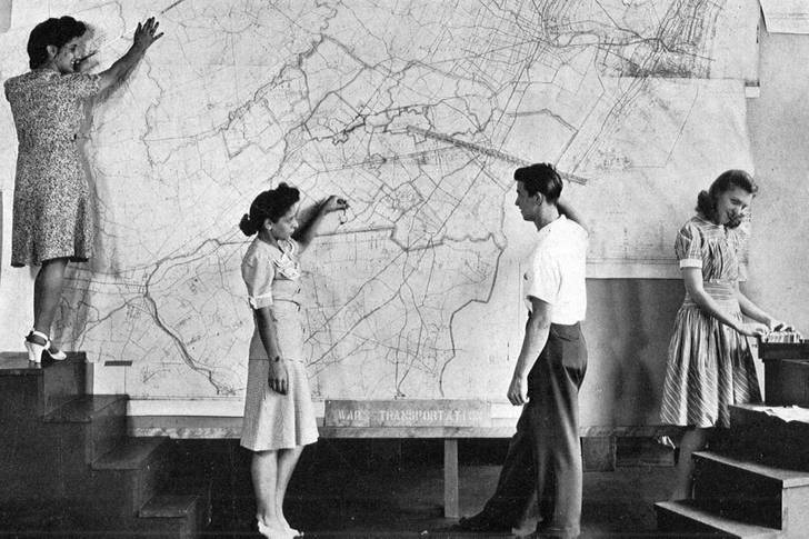 A photo from 1943 showing people standing in front of a map of New York and New Jersey.